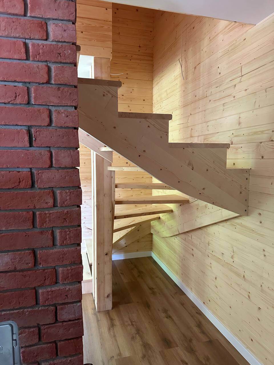 schody drewniane w połączeniu z komenm murowanym cegłą